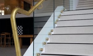 Planar glass balustrade with brass buttons and handrail